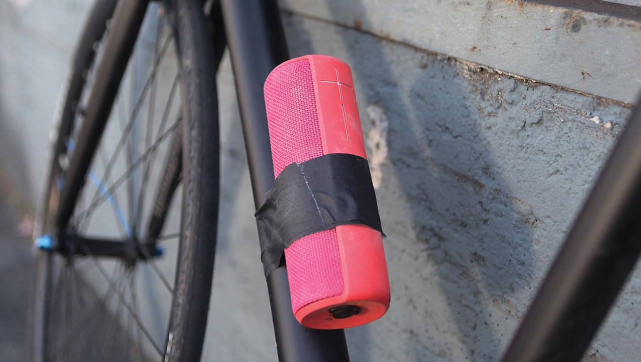 Pink UE Boom portable speaker taped to a bicycle