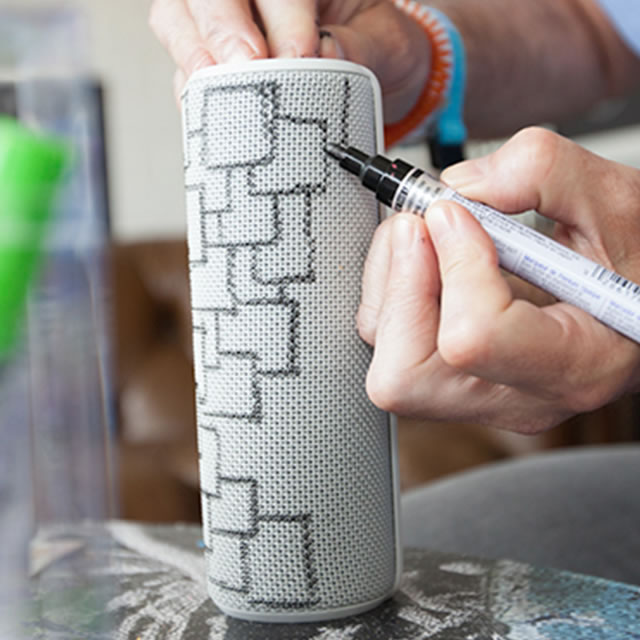 Drawing with markers on a white UE Boom portable speaker